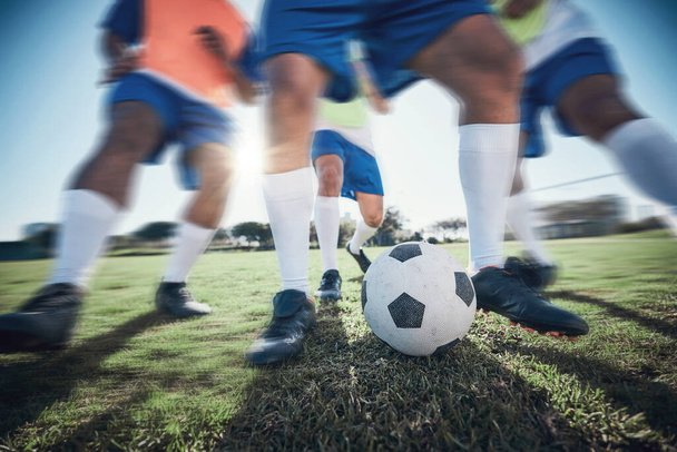 Football player, feet and men with a ball together on a field for sports game or fitness. Blurred closeup of male soccer team or athlete group for tackle challenge, action or training workout outdoor. - Foto, Bild