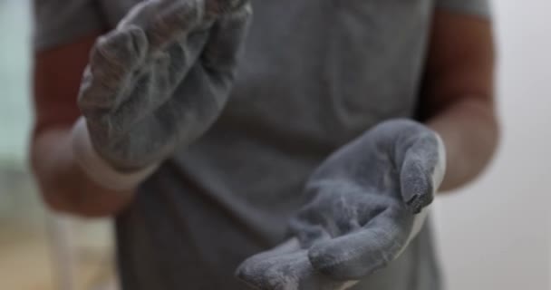 建設労働者は建設現場で手袋を脱ぎ捨てます。家の改装中に保護手袋を洗うビルダー - 映像、動画