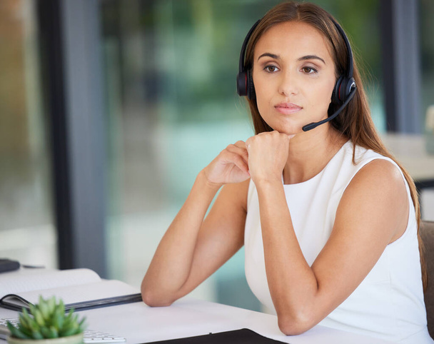 Call center, serious woman and thinking in office of customer service, CRM solution and telecom ideas. Female agent focus with microphone for telemarketing, sales consulting and support at help desk. - Φωτογραφία, εικόνα