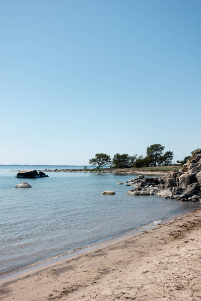 Krásná pobřežní krajina scéna s pískem pláž setkání skály u tyrkysové vody okraj ve Stockholmu souostroví na slunném horkém letním dni - Fotografie, Obrázek