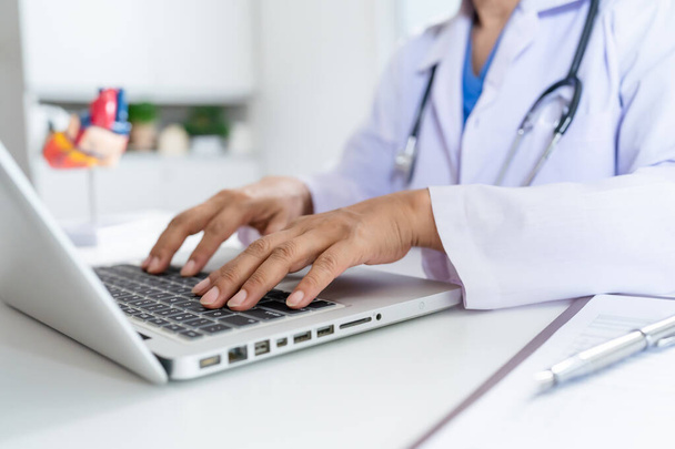 Lekarz skonsultować pacjenta na laptopie z anatomicznym modelem ludzkiego serca Kardiolog wspiera serca Online wizytę lekarza. - Zdjęcie, obraz