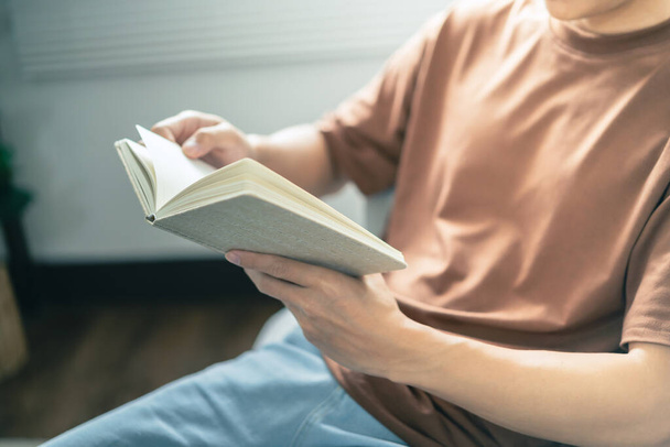 Hombres leyendo libro y relajándose en casa y comodidad delante de libro abierto. - Foto, imagen
