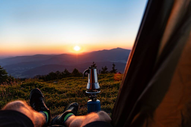 Συσκευή για την παρασκευή καφέ - ένα δοχείο moka σε ένα καυστήρα αερίου μπροστά από μια σκηνή σε μια κορυφή βουνού στα πολωνικά βουνά - Beskidy. Ανατολή ηλίου σε ορεινή κατασκήνωση. - Φωτογραφία, εικόνα