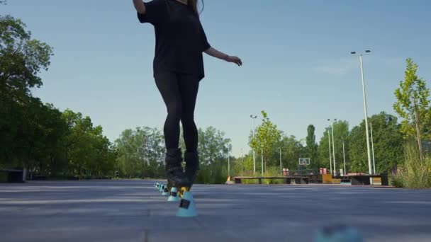 sportos lány gyakorló trükkök görkorcsolya park városi háttér élvezi görkorcsolyázás lecke bóják közeli utcai sport - Felvétel, videó