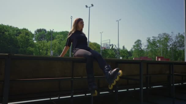 Sportliches Mädchen nach Inlineskaten auf dem Sportplatz nachdenklich glücklich mit der Straßensportstunde - Filmmaterial, Video