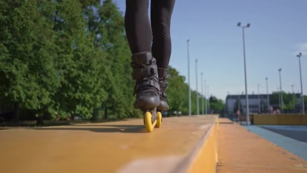 sportos lány gyakorló trükkök görkorcsolya park város háttér élvezi görkorcsolya lecke közeli lábak utcai sport - Felvétel, videó