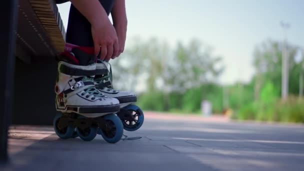 νεαρή hipster κορίτσι βάζει σε πατίνια στο πάρκο skate πριν από την έναρξη skating δρόμο extreme sport κοντά πόδια - Πλάνα, βίντεο
