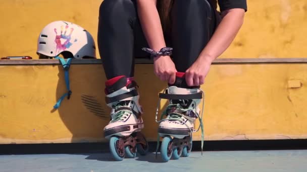 młoda dziewczyna hipster noszenia rolki sznurowadła wiązania w skate parku przed łyżwiarstwo ulicy ekstremalne sportowe zbliżenie nóg - Materiał filmowy, wideo