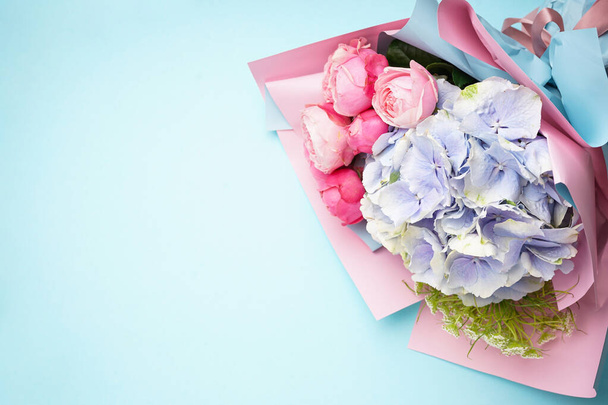 Bouquet di rose di peonia con ortensia su fondo blu, spazio per testo. Posa piatta. - Foto, immagini