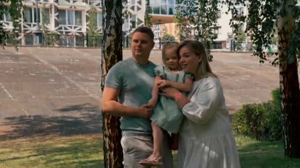 Retrato de uma família jovem sorridente mãe pai e filha pequena família em um passeio no parque infância feliz - Filmagem, Vídeo