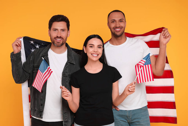 4th of July - Independence Day of USA. Happy friends with American flags on yellow background - Foto, imagen