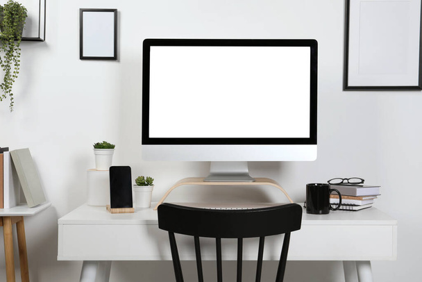 Acogedor espacio de trabajo con ordenador, smartphone y papelería en escritorio de madera en casa - Foto, imagen
