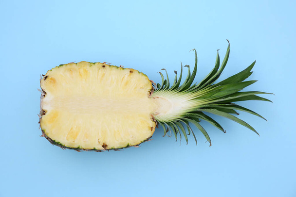 Half of ripe pineapple on light blue background, top view - Photo, Image