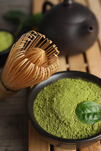 Green matcha powder and bamboo whisk on table, closeup - Foto, Bild