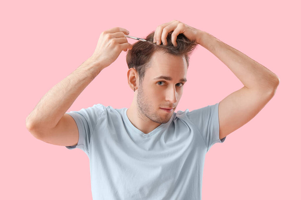 Young man making injection for hair growth on pink background - Foto, Bild