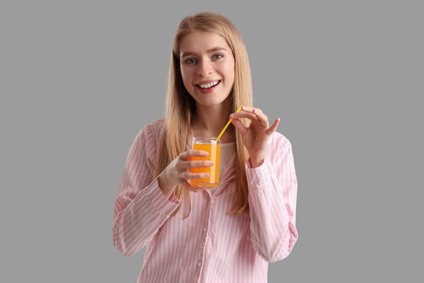Young woman with glass of vegetable juice on grey background - Foto, Bild