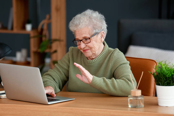 Seniorin arbeitet im Büro mit Laptop - Foto, Bild