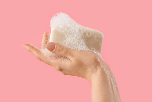 Hand met zeep op roze achtergrond - Foto, afbeelding