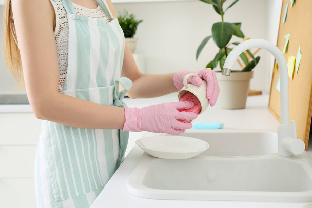 Woman washing cup with sponge in kitchen, closeup - Foto, afbeelding