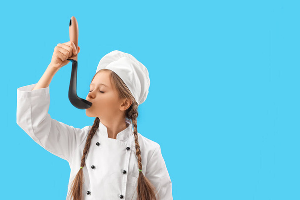 Pequeño chef con cuchara sobre fondo azul - Foto, imagen