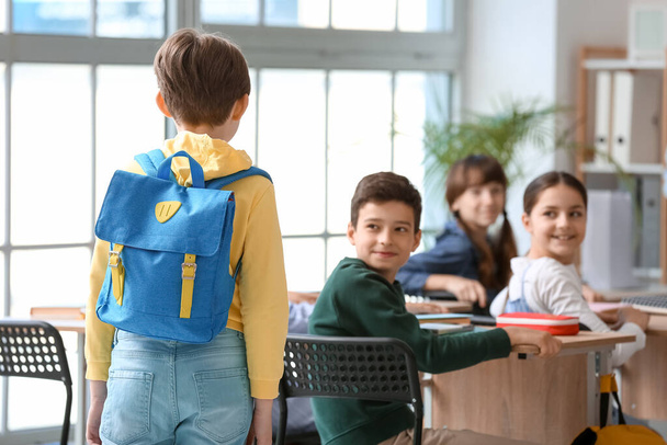 Мальчик с рюкзаком в классе, вид сзади - Фото, изображение