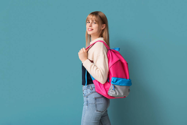 Female student with backpack on blue background - Фото, зображення