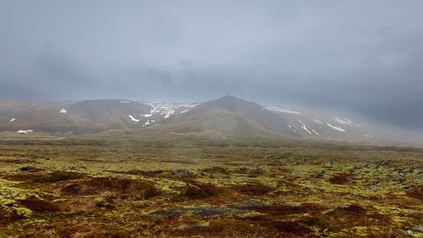 Облака покрывают горы посреди ландшафта Тундры в сельской местности Исландии. - Фото, изображение