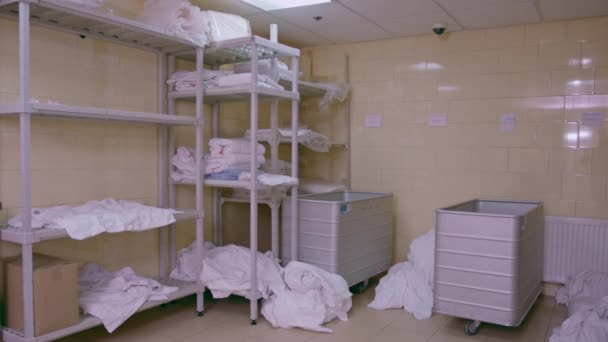 ホテルの汚れたベッドリネンの産業洗濯は洗濯機の清潔さおよびおもてなしの概念に荷を積まれる前に分類される床にあります - 映像、動画
