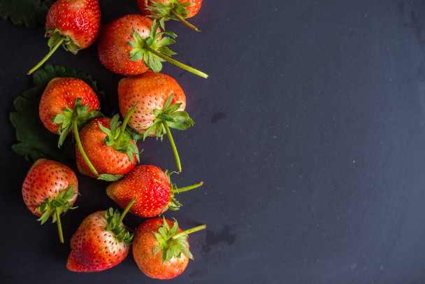 Red fresh strawberry on black plate vitamin fruit - Фото, зображення