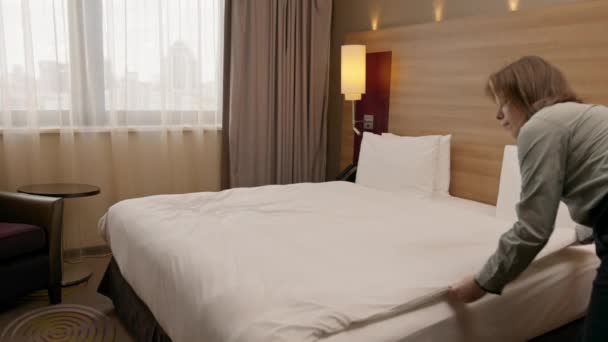 retrato da jovem empregada doméstica no hotel menina limpa quarto faz branco limpo cama limpeza hospitalidade conceito - Filmagem, Vídeo