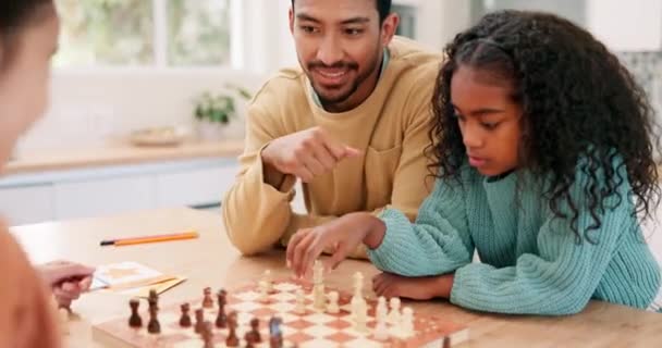 Familie, vader en kinderen spelen schaak aan een tafel tijdens het lesgeven en leren bordspel. Gelukkig man en meisje kinderen samen thuis voor ontwikkeling, probleemoplossing en strategie voor leuke competitie. - Video