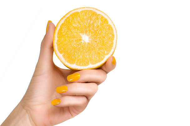 Mano con uñas amarillas sosteniendo una fruta de limón. Aislado
 - Foto, imagen