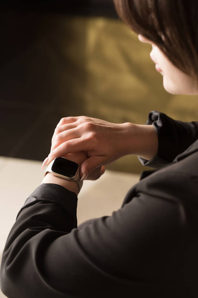 Young office worker looking at smart watch, hands close-up - Foto, imagen