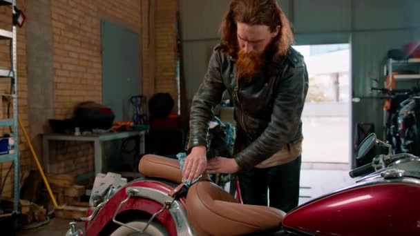 Oficina de motocicleta autêntica criativa Reparação de garagem mecânica motocicleta limpa poeira com pano - Filmagem, Vídeo