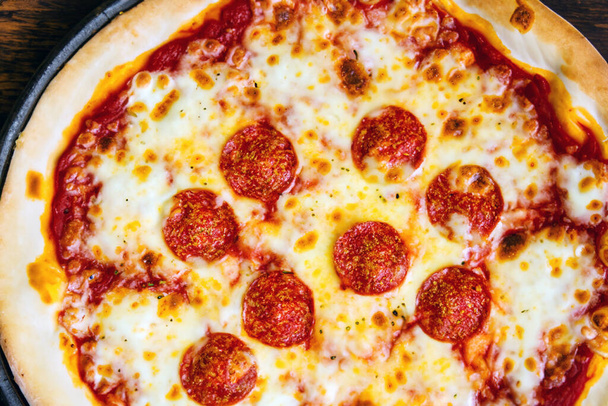 Uma imagem de uma pizza tradicional italiana. Na Itália, a pizza servida em um restaurante é apresentada sem fatias e é comida com o uso de faca e garfo. - Foto, Imagem