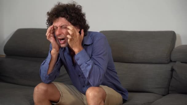 man with a headache on the sofa - Footage, Video