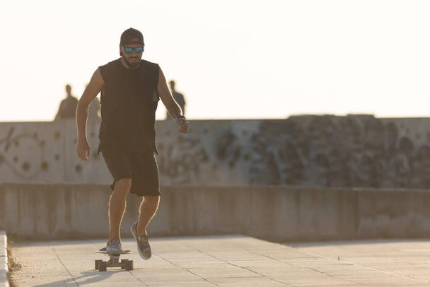 Erwachsene lächelnde attraktive Mann Skateboarding auf der Straße. Mittelschuss - Foto, Bild