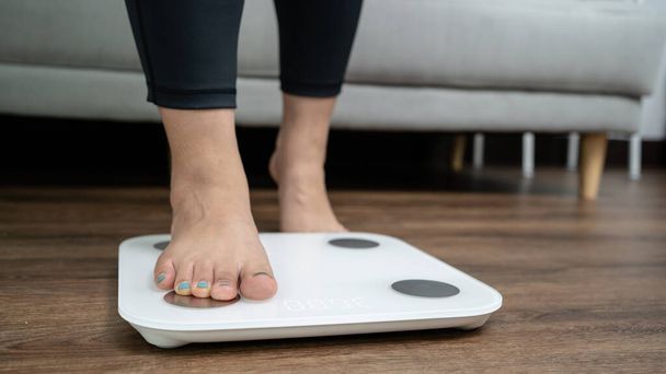 足は体重管理のため電子スケールに立っています。ダイエットコントロールのためのキログラムで測定器. - 写真・画像