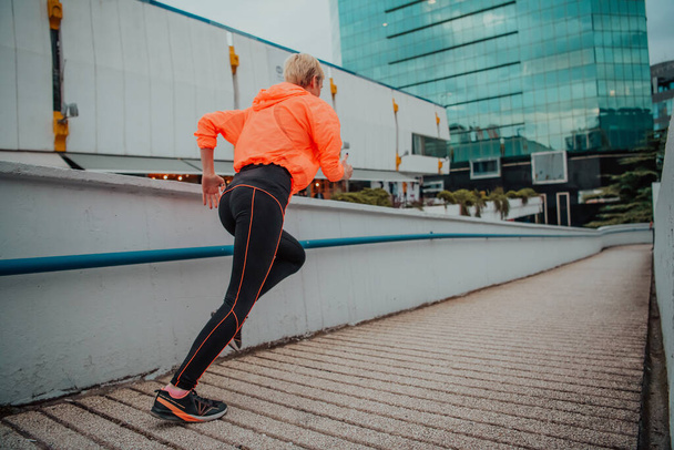 Women in sports clothes running in a modern urban environment. The concept of a sporty and healthy lifestyle.  - 写真・画像