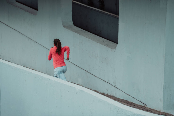 Women in sports clothes running in a modern urban environment. The concept of a sporty and healthy lifestyle.  - Foto, Imagem
