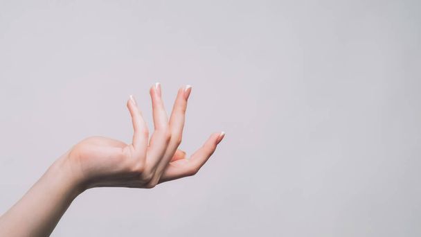 Give me. Outstretching gesture. Woman hand demanding product reaching arm to have produce isolated on gray copy space background. - Photo, image