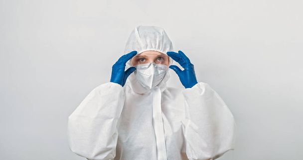 Environmental danger. Water contamination. Cholera infection. Confident woman scientist in protective coverall suit mask putting on goggles isolated on grey background. - Fotoğraf, Görsel