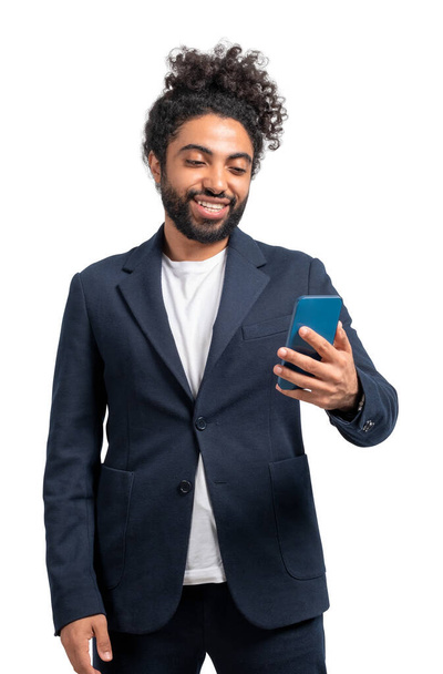 Middle eastern businessman smiling and looking at phone, video call and connection, isolated over white background. Concept of online network - Фото, зображення