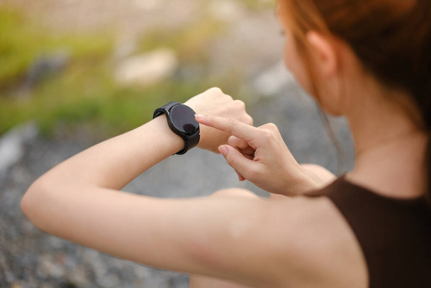 Burning calories. Cropped closeup of a fit woman looking at her smart watch counting burned calories during her workout at the gym. Woman using fitness bracelet copyspace. High quality photo - Foto, Imagem