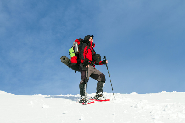 Winter hiking in the mountains on snowshoes with a backpack and tent. - Photo, Image