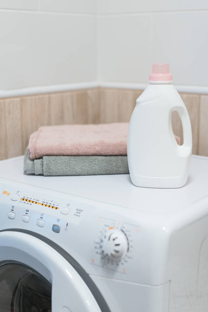 Washing gel liquid laundry detergent and fabric softener on washing machine, clean towels on washing machine. High quality photo - Foto, Imagem