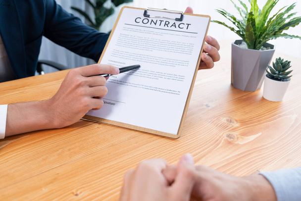 Businessman carefully reviewing contract document for corporate partnership. Client reading agreement deal and terms on meeting table for professional business decision. Entity - Photo, Image