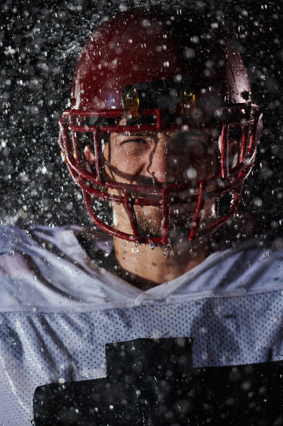 American Football Field: Lonely Athlete Warrior Standing on a Field Holds his Helmet and Ready to Play. Player Preparing to Run, Attack and Score Touchdown. Rainy Night with Dramatic Fog, Blue Light. - Fotó, kép