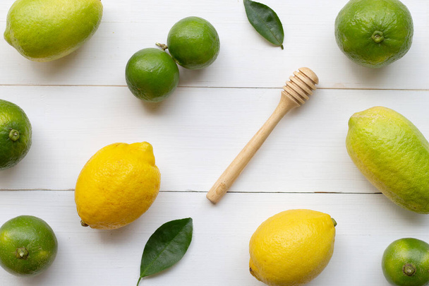 Спелые лимоны и лаймы на белом деревянном фоне
. - Фото, изображение