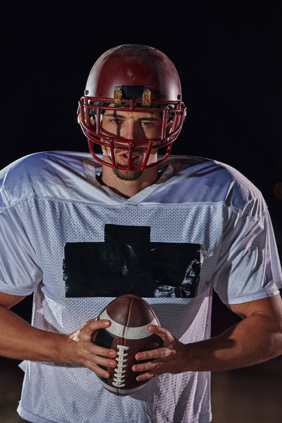 American Football Field: Lonely Athlete Warrior Standing on a Field Holds his Helmet and Ready to Play. Player Preparing to Run, Attack and Score Touchdown - Foto, immagini